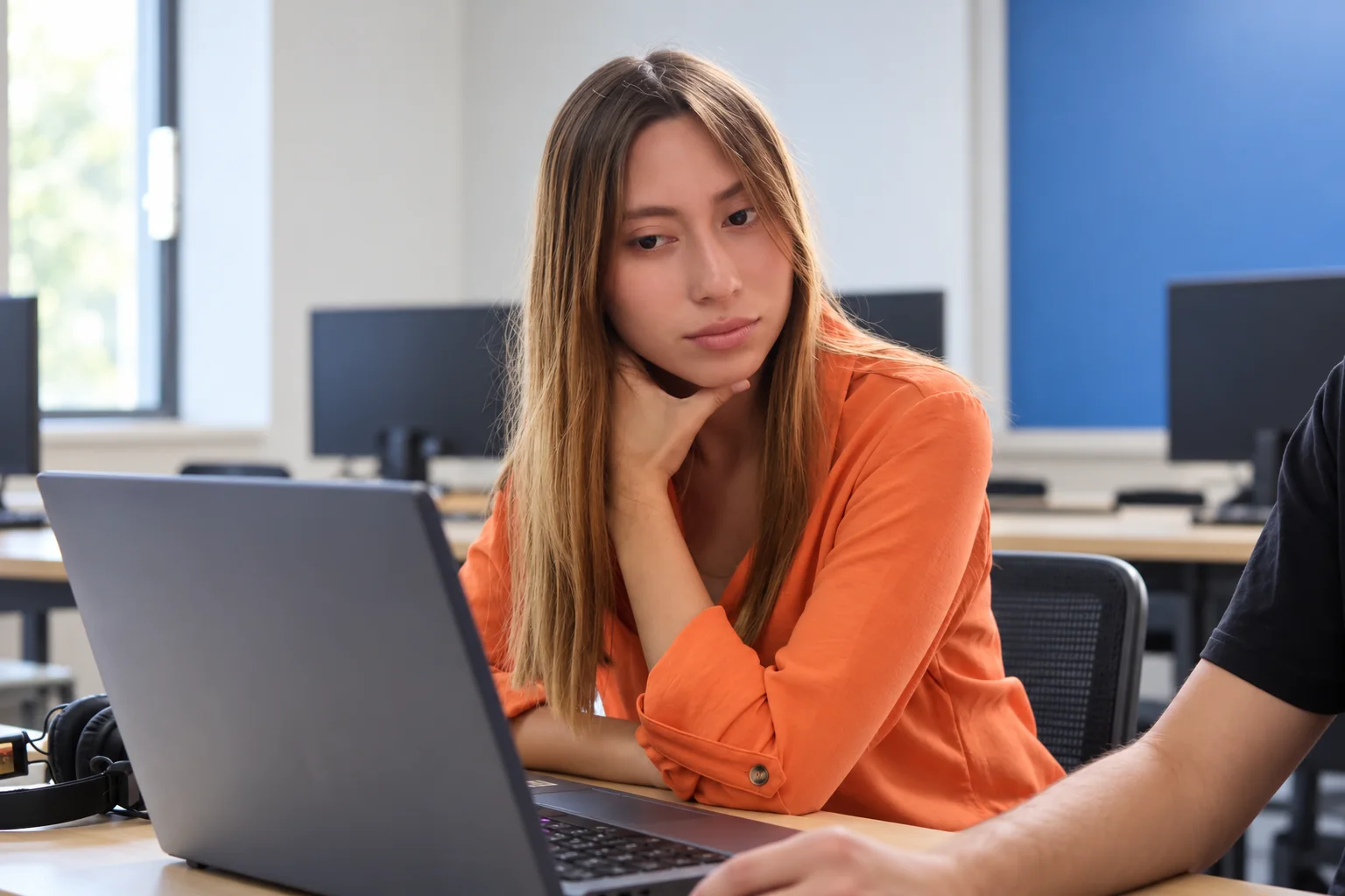 Estudiante trabaja con una computadora en el aula.